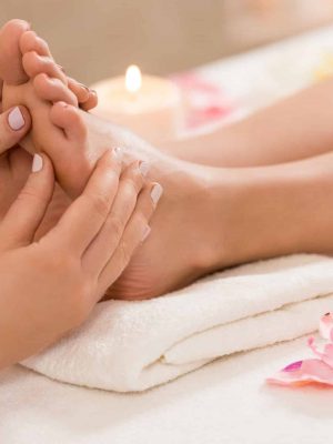 cropped view of massage therapist making feet massage in spa salon